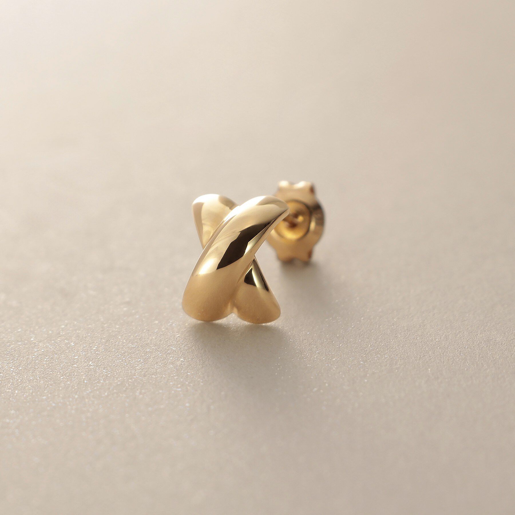 COCOSHNIK「K18【サステナブル】甲丸クロスアーチ スタッドピアス」|ピアス|